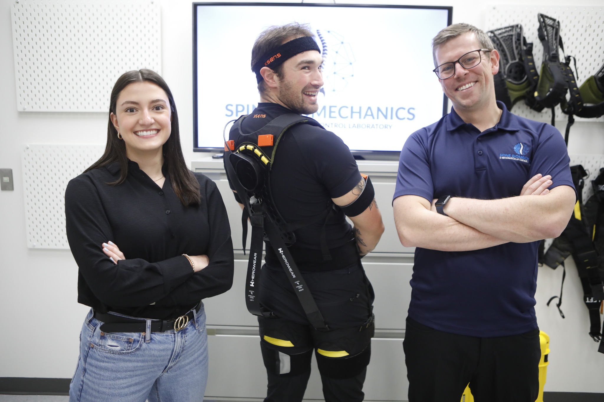Lab trainees and Shawn Beaudette demonstrating a back-support exoskeleton and wearable motion sensors.